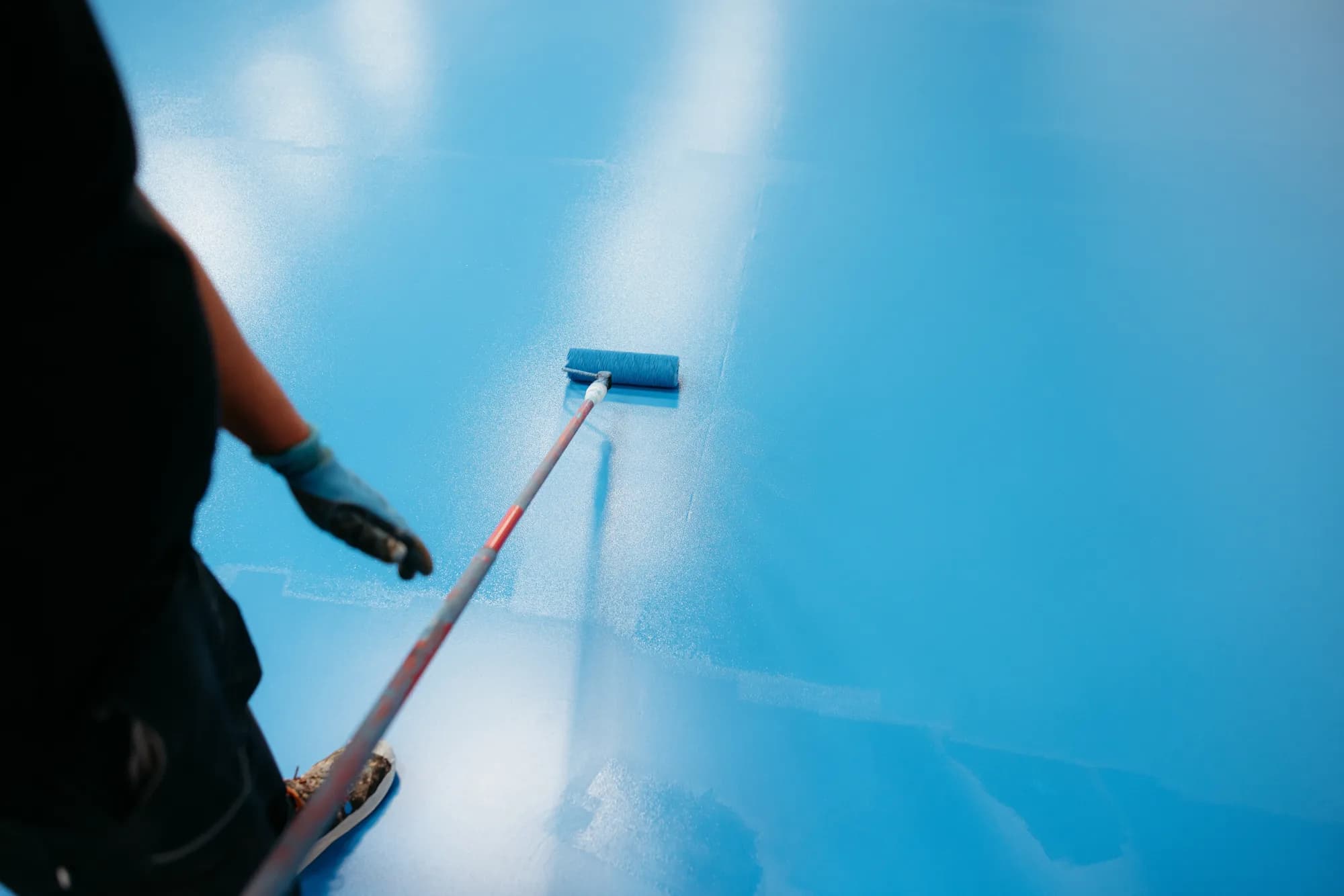 Blaue Bodenbeschichtung wird mit der Rolle aufgetragen