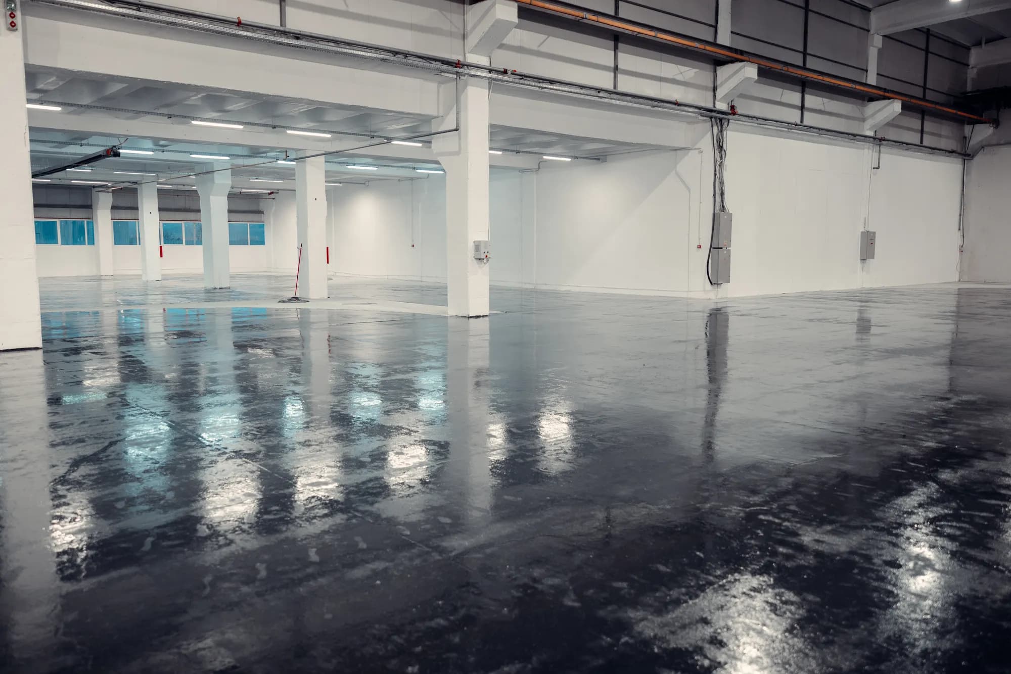 Industriehalle mit dunkler, glänzender Epoxidharz-Bodenbeschichtung