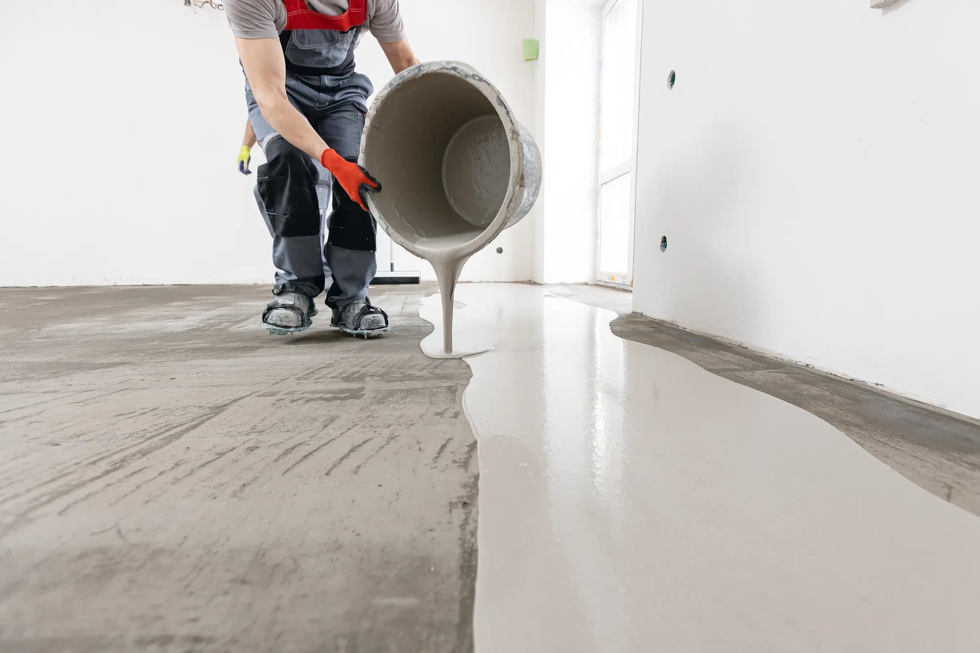 Auftragen von Ausgleichsmasse bei der Bodensanierung eines Betonbodens